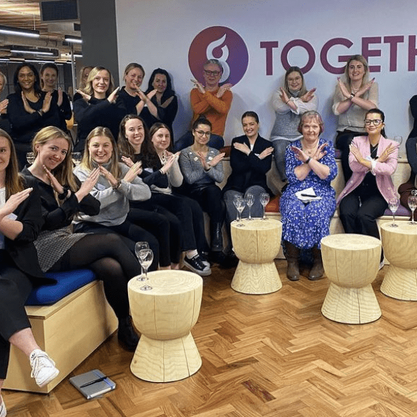 Alt='Group of women sat inside Grayce office'